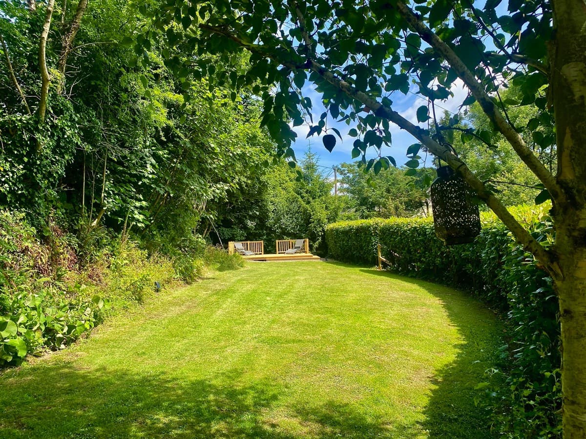 Enjoy the peaceful ambiance of the secret garden deck at the Sunridge Cubes - Sunridge Retreats