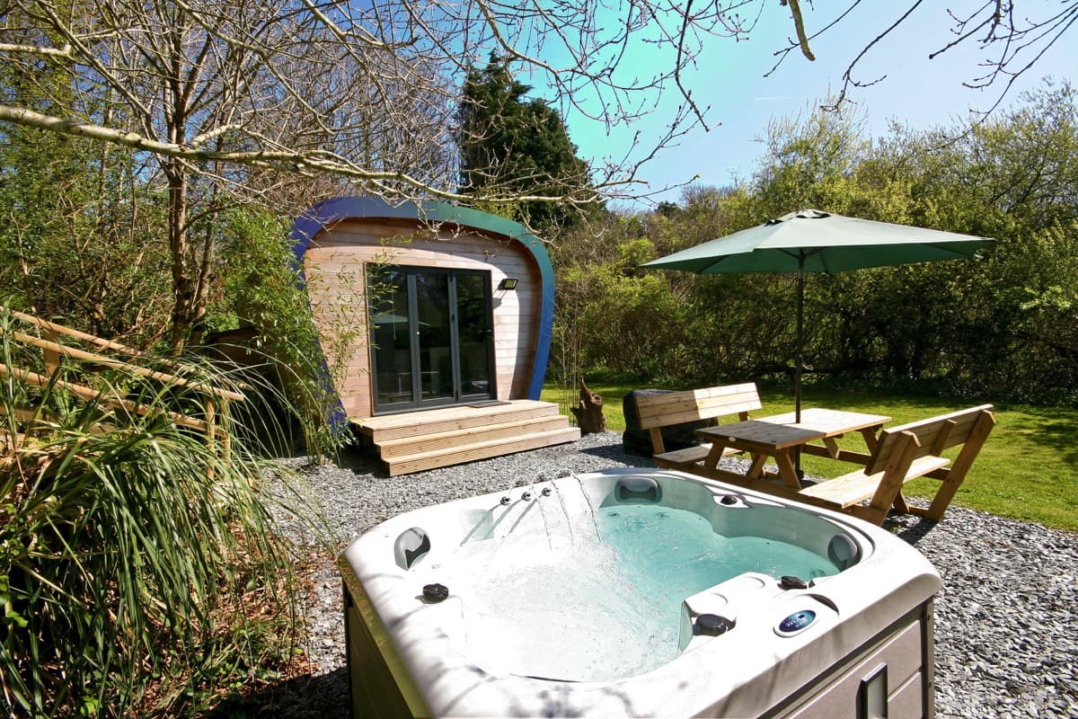 Blissful relaxation in the sun-drenched hot tub with the Ecopod as a picturesque backdrop