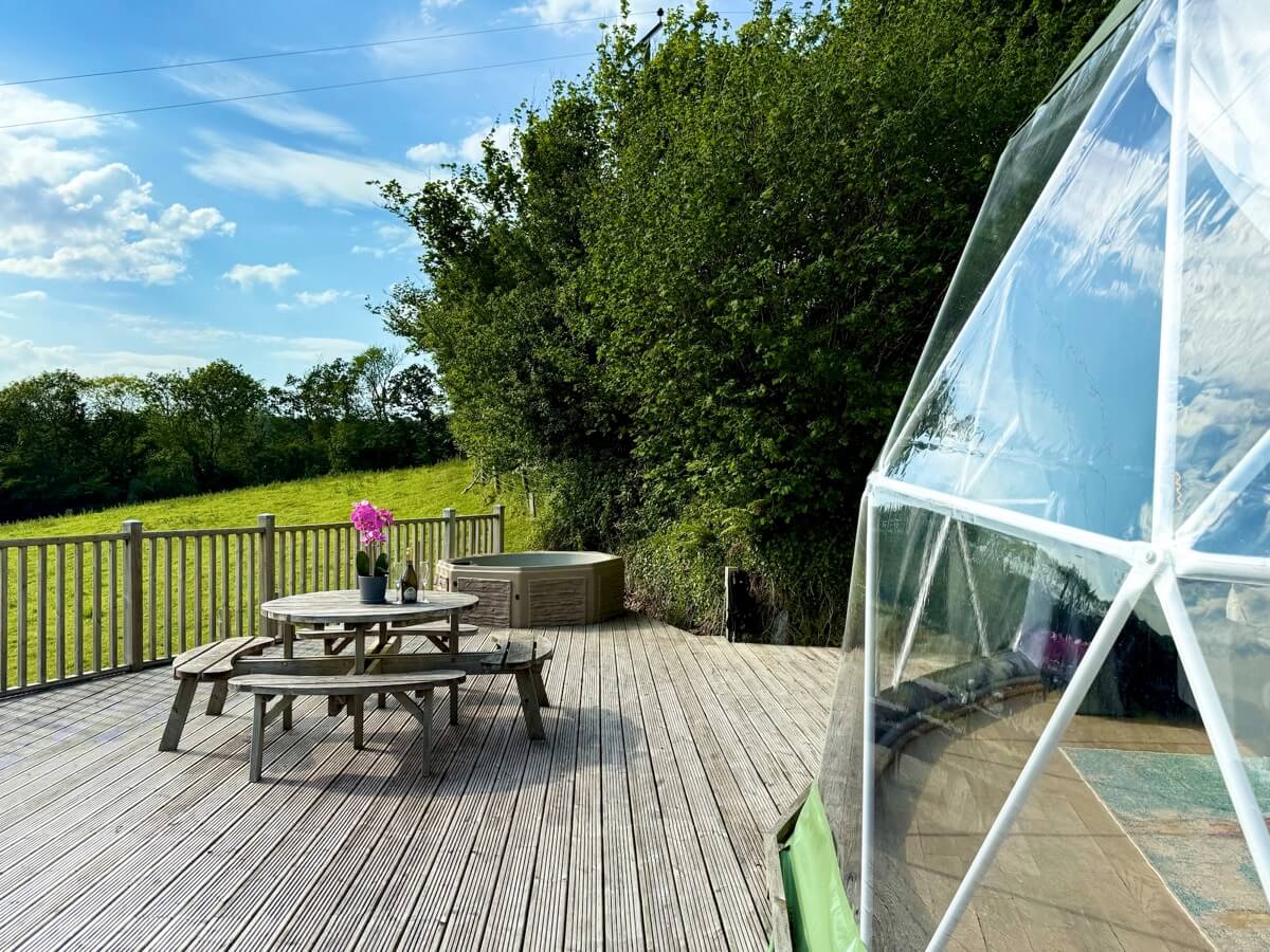 Expansive wraparound deck with BBQ and countryside backdrop