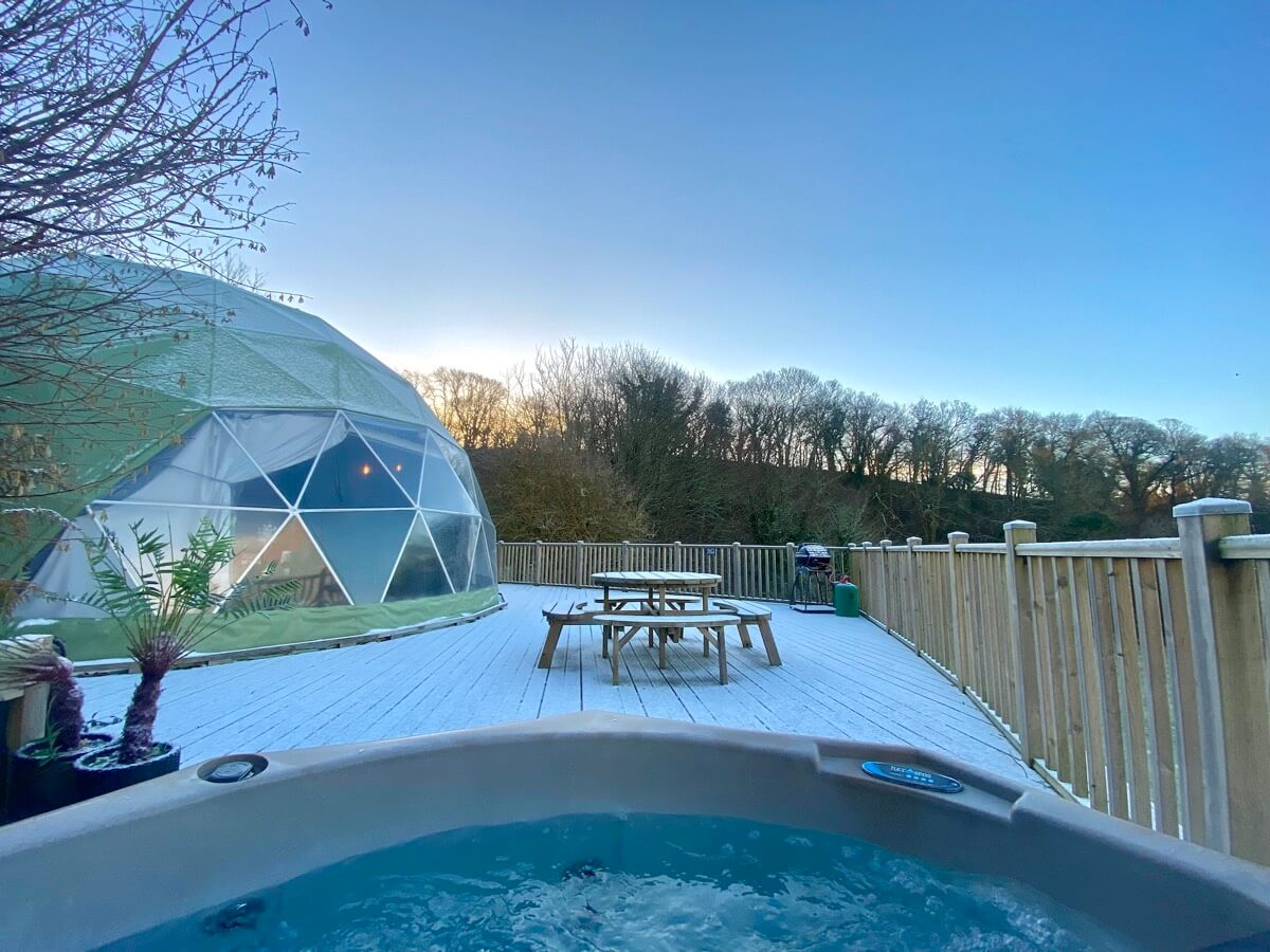 Geodome in winter sun with hot tub.