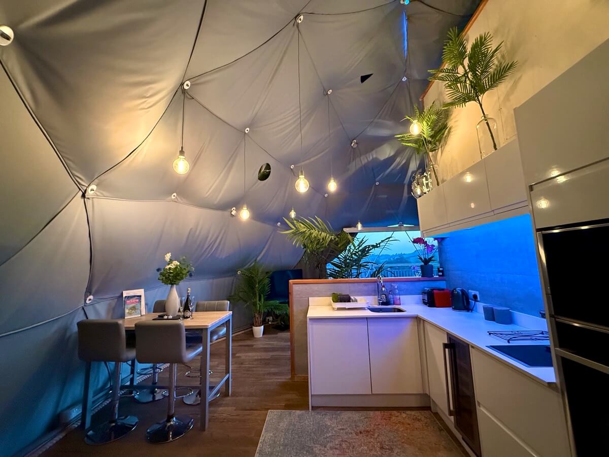 Blue-hued dining and kitchen area inside the dome