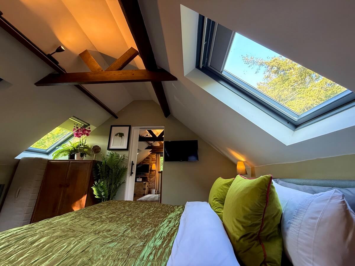 Cosy bedroom under angled ceiling with skylight.