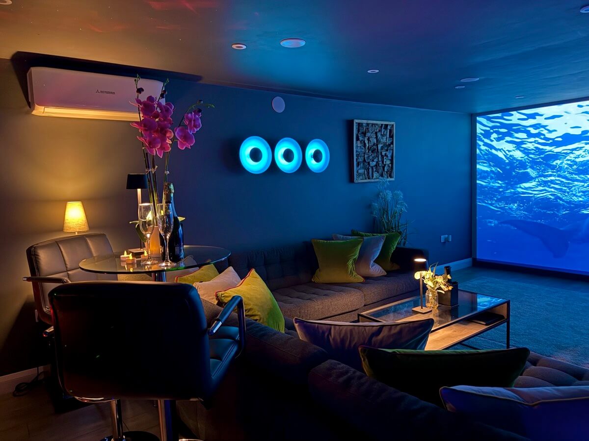 The Hub cinema room with mood lighting and projector screen wall.