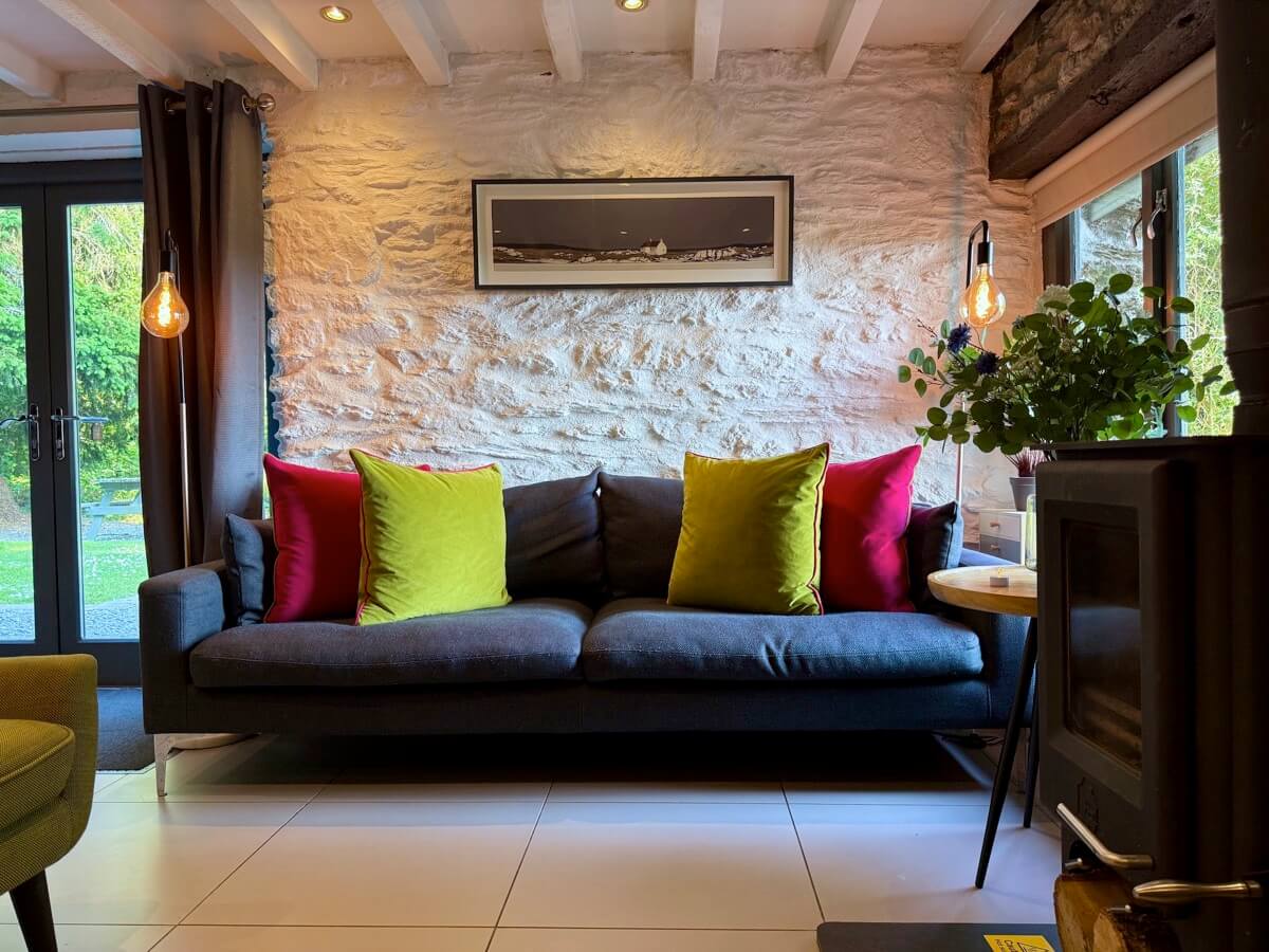 Main lounge area with bright cushions and patio doors.