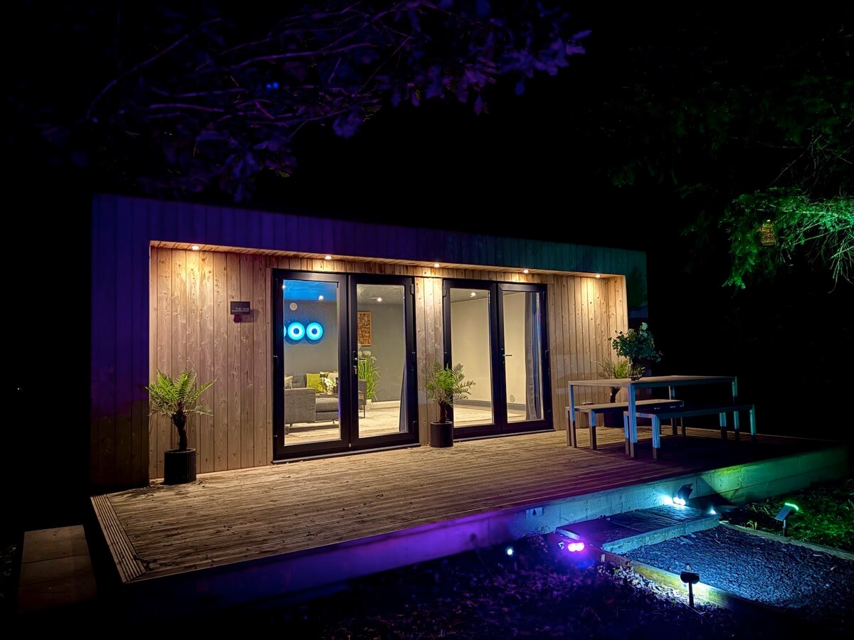 The Hub lit up at night with decked seating.