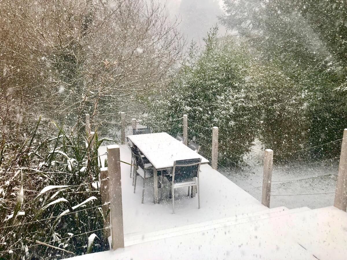 Serenity in the snow: Deck area surrounded by winter wonderland at Sunridge Lodge