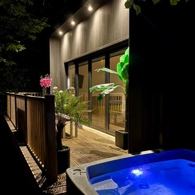 Nighttime bliss at Sunridge Cubes: Illuminated hot tub with a stylish Cube in the background, creating a magical ambiance