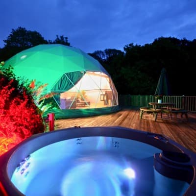 Stunning Geodome at Sunridge Retreats: Experience luxury and relaxation in the beautifully lit exterior of the Geodome, featuring a private hot tub for ultimate indulgence.