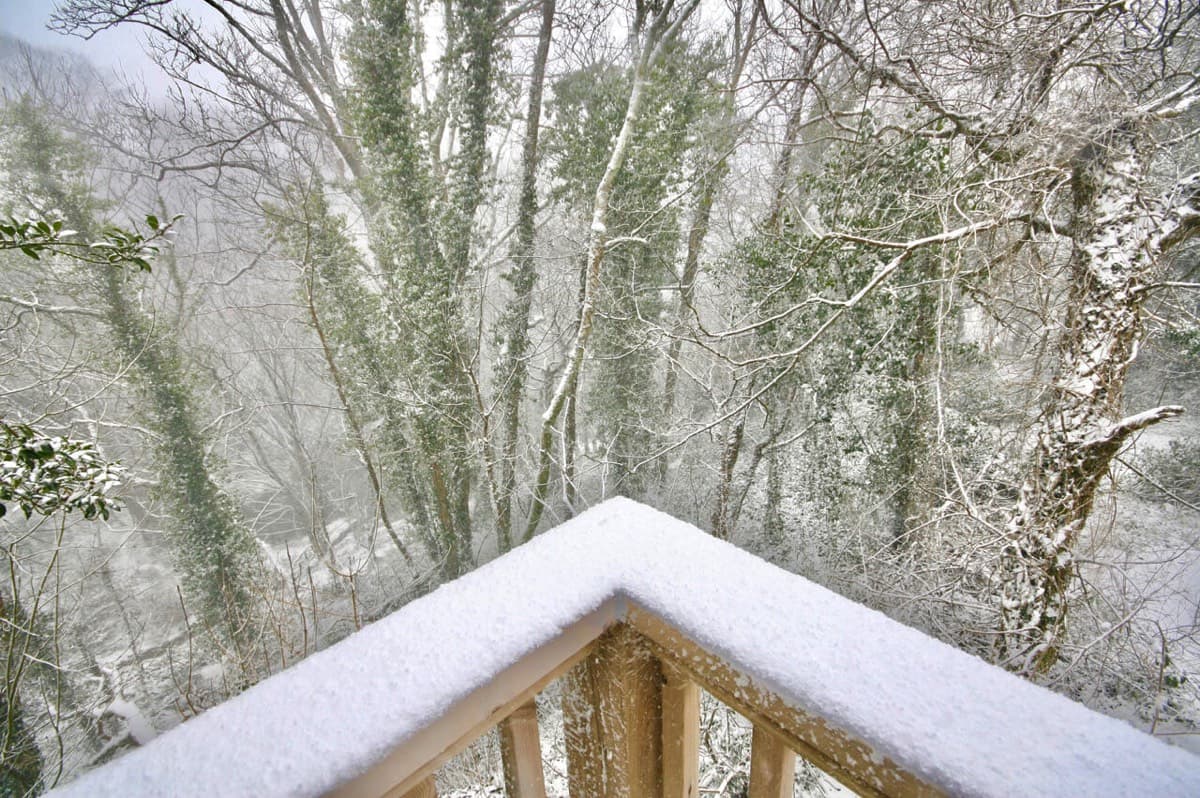 Sunridge Treehouse balcony overlooking the snow-covered countryside