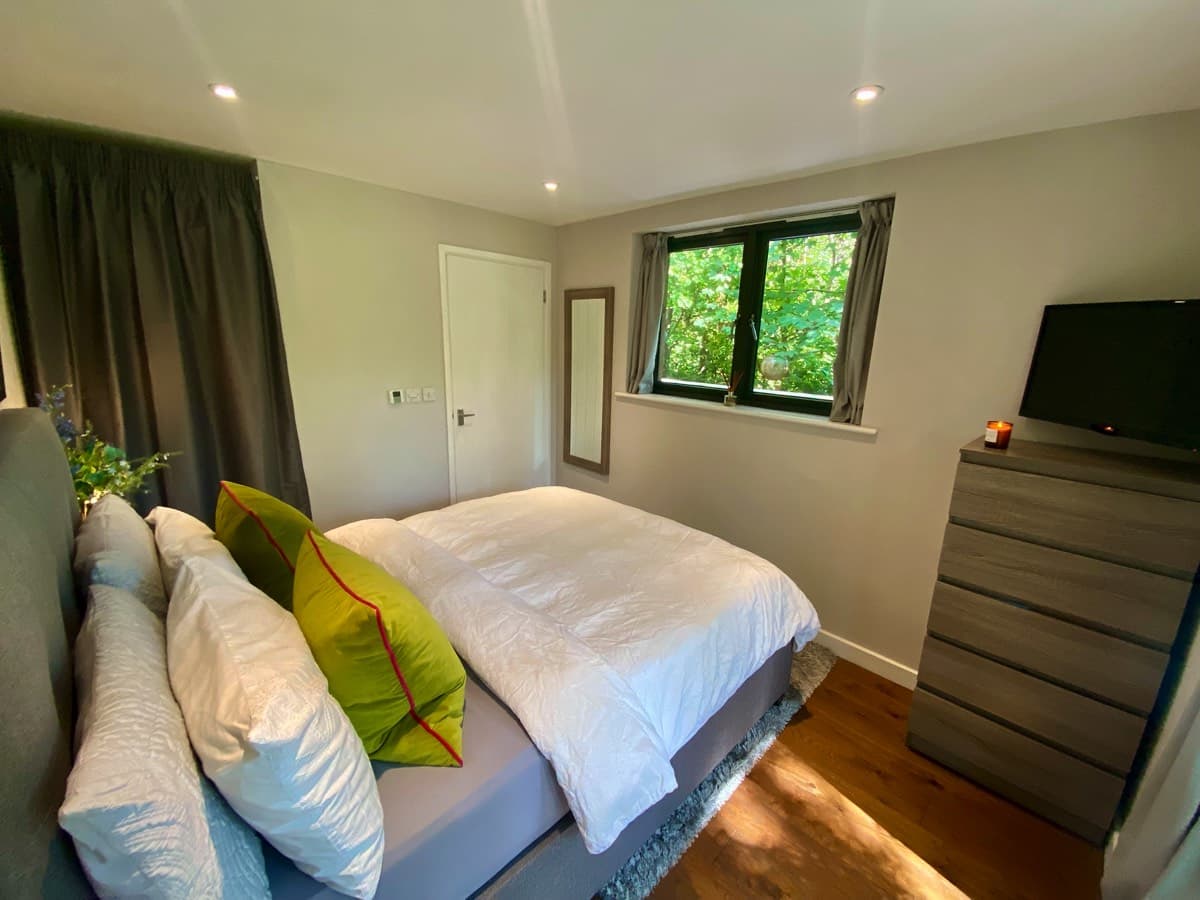 Warm and inviting ensuite bedroom in the treehouse, blending comfort with nature.