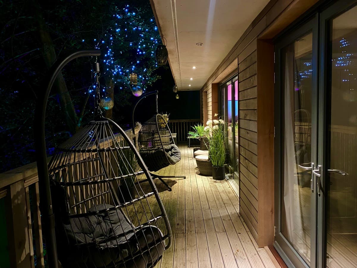 Twinkling fairy lights illuminating the upper deck, casting a magical glow over the treehouse